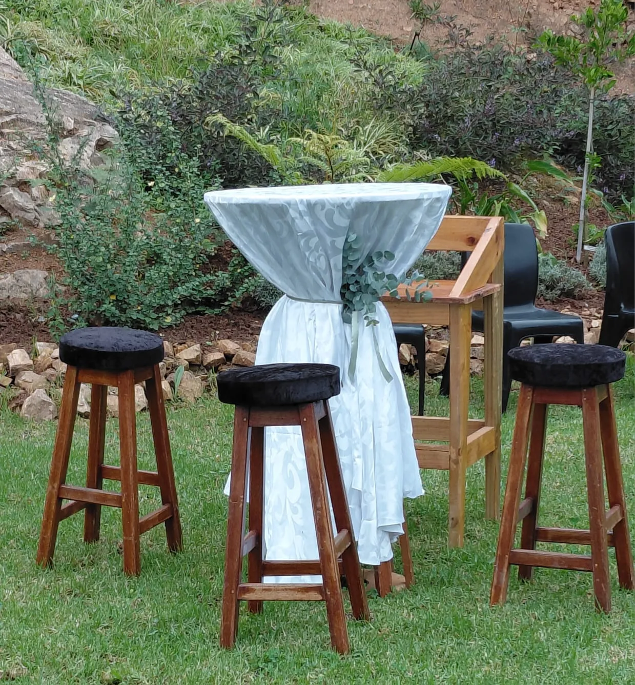 A dressed cocktail table and bar stools on the lawn