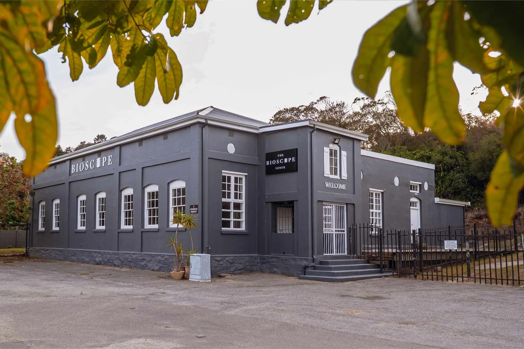 The Bioscope Venue from the road: a charcoal single-storey building with white sash windows and the projector room above the entrance